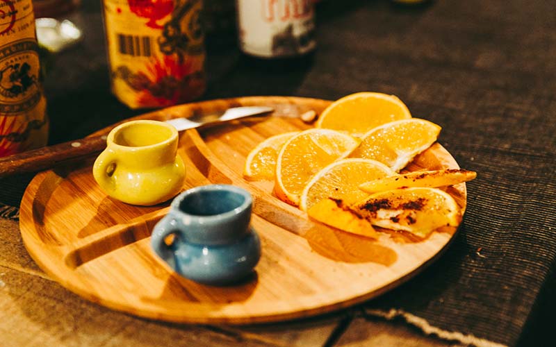 Pltos de madera con limon, sal, tequila y naranjas